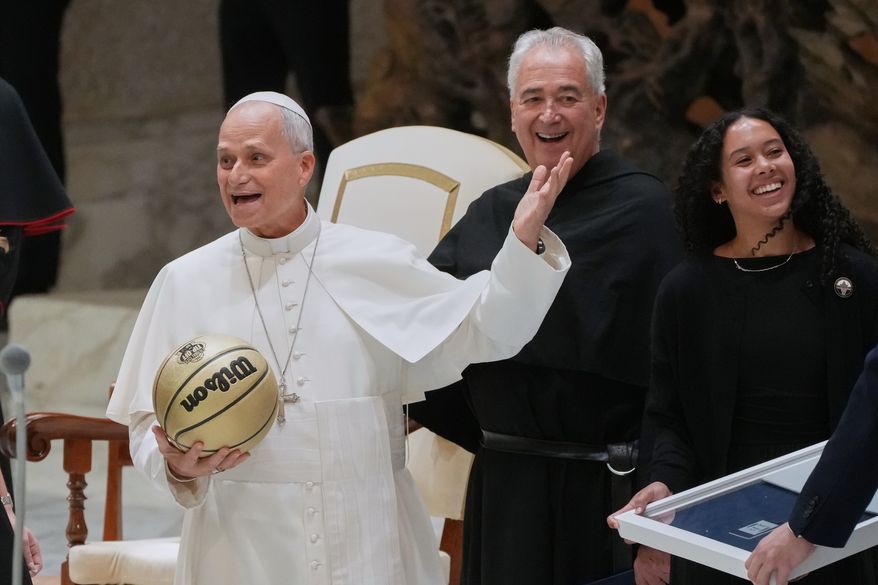 From right Villanova basketball player Jasmine Bascoe along with Villanova University President Peter M. Donohue, present Pope Leo XIV with a basketball in the Paul VI Hall at the Vatican, Saturday, Oct. 31, 2026, during an audience with some 7,000 university representatives ahead of the Eternal City Tip-Off, a men's and women's college basketball doubleheader in Rome on Nov. 1. (AP Photo/Gregorio Borgia)