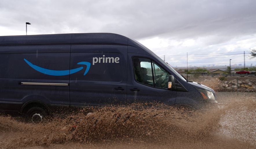 A delivery driver goes through a flooded road on Friday, Oct. 30, 2026, in Henderson, Nev. (AP Photo/Ty ONeil)