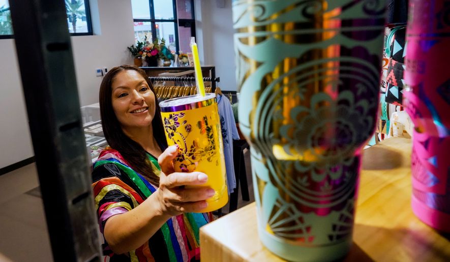 Fawn Douglas puts a cup on a shelf at IndigenousAF, her store and gallery in Las Vegas, Thursday, Oct. 29, 2026. (AP Photo/Ty ONeil)