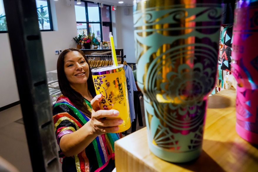 Fawn Douglas puts a cup on a shelf at IndigenousAF, her store and gallery in Las Vegas, Thursday, Oct. 29, 2026. (AP Photo/Ty ONeil)
