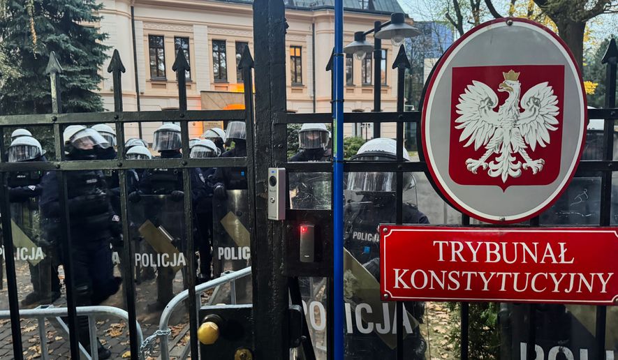 Police officers guard the entrance to the Polish Constitutional Court in Warsaw, Poland, Saturday, Oct. 31, 2026. (AP Photo/Rafal Niedzielski) Photo taken with a smartphone.