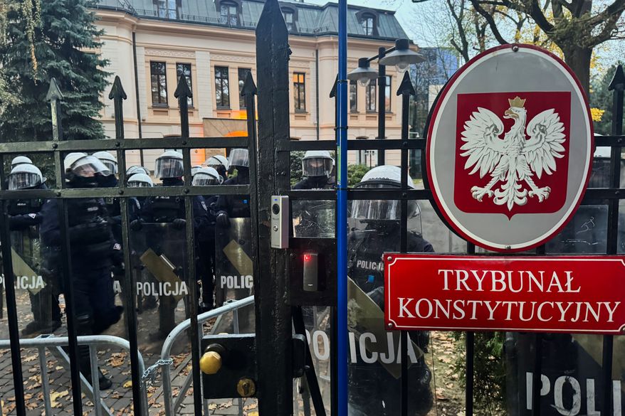 Police officers guard the entrance to the Polish Constitutional Court in Warsaw, Poland, Saturday, Oct. 31, 2026. (AP Photo/Rafal Niedzielski) Photo taken with a smartphone.